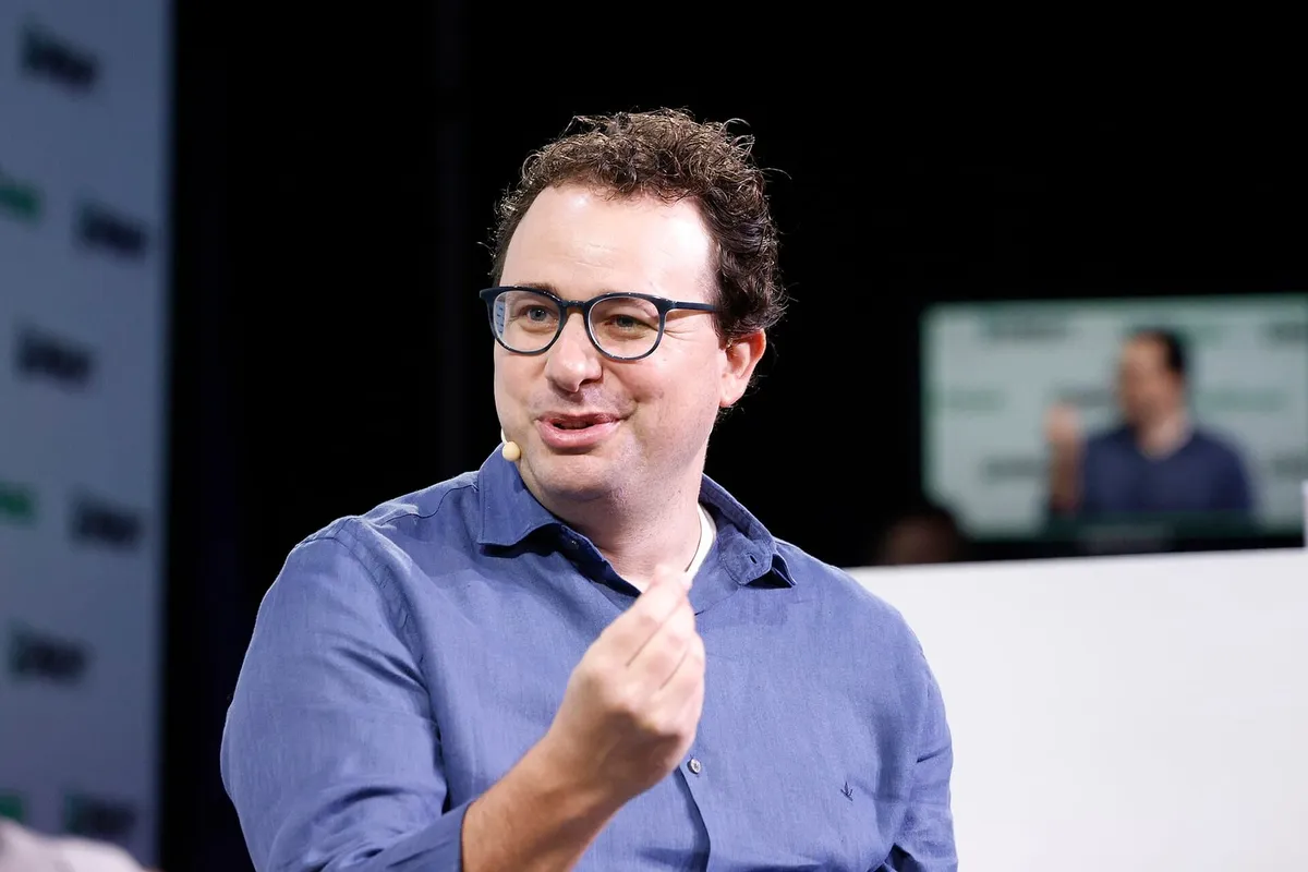 Dario Amodei speaking on stage in a blue shirt