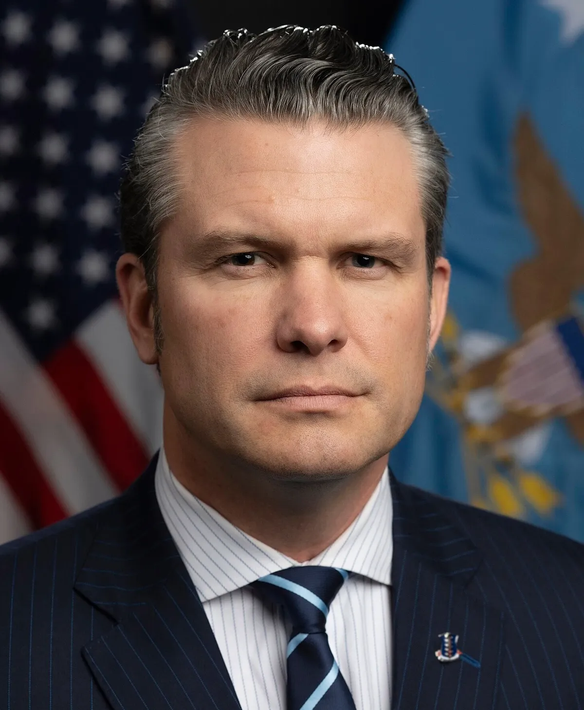 Official portrait of Pete Hegseth in front of U.S. flags
